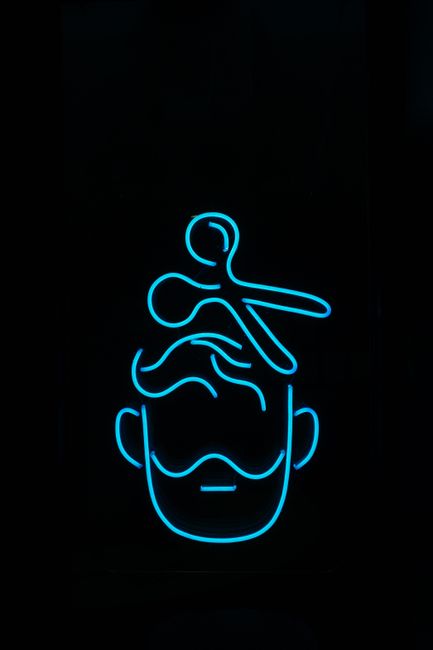 Line-art icon of a barber's scissors and comb over a head